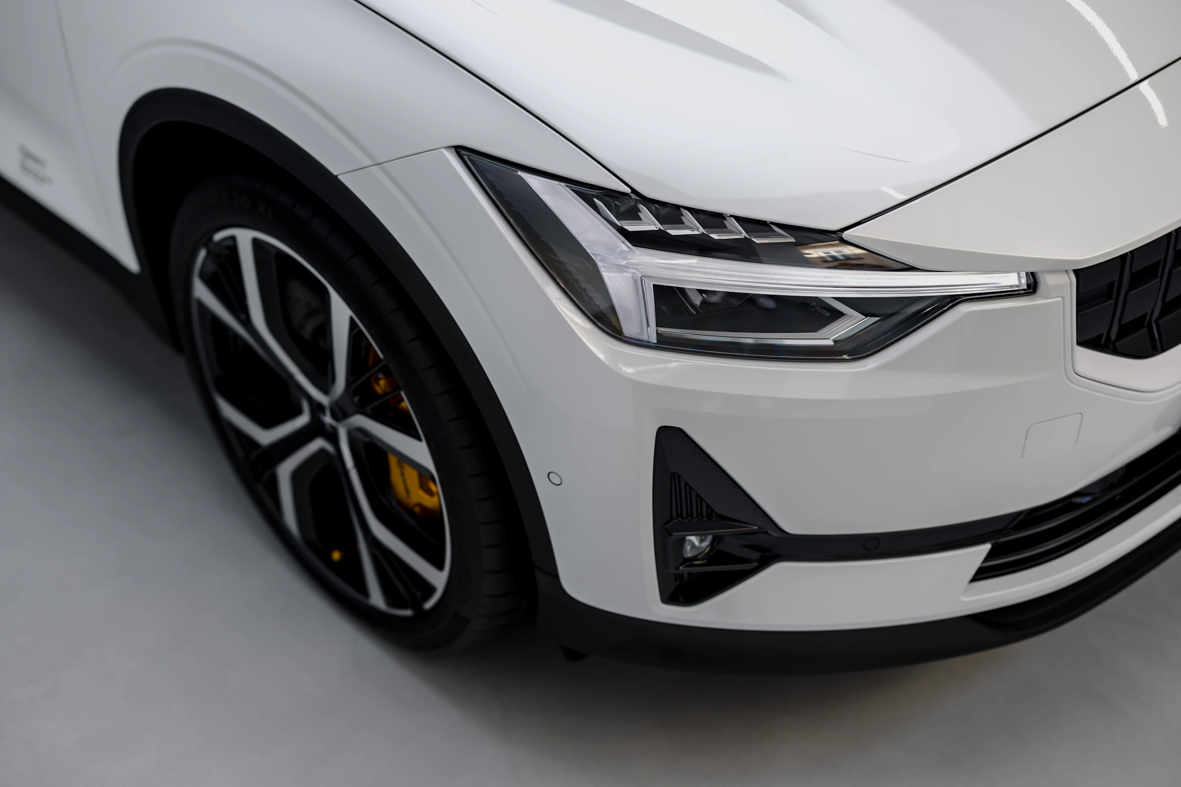 Headlight and bodywork details of a white car